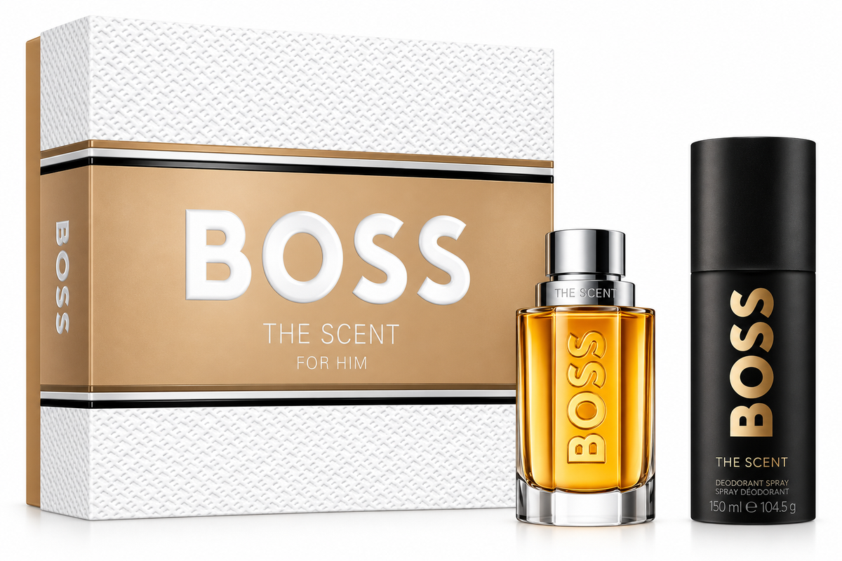 Hugo Boss The Scent for Him gift set featuring an elegant amber-colored perfume bottle with silver cap, a black 150ml deodorant spray with gold lettering, and a luxurious white textured gift box with gold detailing. Sophisticated men's fragrance gift set on a clean white background.